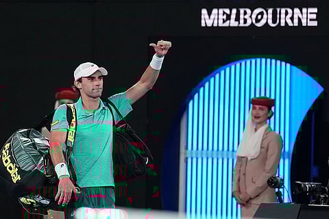 Eliot Spizzirri of the U.S. waves as he leaves the court following his third round loss to Jannik Sinner of Italy at the Australian Open tennis championship in Melbourne, Australia.