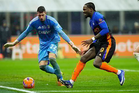 Inter Milan's Marcus Thuram, right, is challenged by Pisa's goalkeeper Simone Scuffet during a Serie A soccer match between Inter Milan and Pisa, in Milan, Italy.