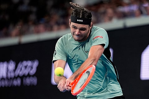 Taylor Fritz of the U.S. plays a backhand return to Stan Wawrinka of Switzerland during their third round match at the Australian Open tennis championship in Melbourne, Australia.