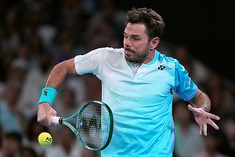 Stan Wawrinka of Switzerland plays a backhand return to Taylor Fritz of the U.S. during their third round match at the Australian Open tennis championship in Melbourne, Australia.