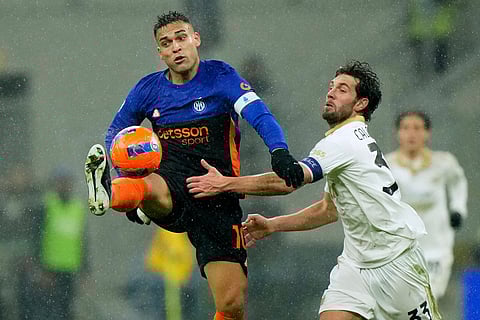 Inter Milan's Lautaro Martinez is challenged by Pisa's Arturo Calabresi, right, during a Serie A soccer match between Inter Milan and Pisa, in Milan, Italy.