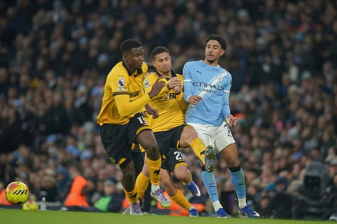Manchester City's Omar Marmoush, right loses possession to Wolverhampton Wanderers' Rodrigo Gomes during the English Premier League soccer match between Manchester City and Wolverhampton Wanderers in Manchester, England.