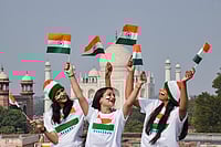 | Photo: PTI : Women celebrate by holding Indian national flags on the eve of Republic Day, at the Taj Mahal in Agra.
