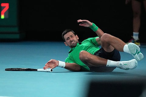 Novak Djokovic of Serbia falls during his third round match against Botic van de Zandschulp of the Netherlands at the Australian Open tennis championship in Melbourne, Australia.