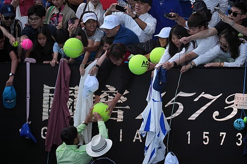 Carlos Alcaraz of Spain signs autographs after defeating Tommy Paul of the U.S. in their fourth round match at the Australian Open tennis championship in Melbourne, Australia.
