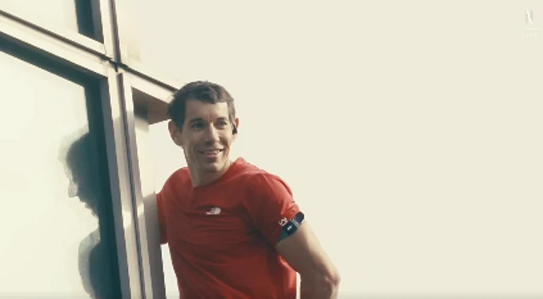 Alex Honnold smiles during his ascent to the Taipei 101 building - Screengrab/Netflix