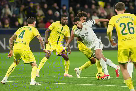 Real Madrid's Jude Bellingham takes on the Villarreal defence during a Spanish La Liga soccer match between Villarreal and Real Madrid in Villarreal, Spain.