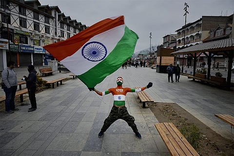 Arun Haryanvi, 35, from Gujarat, an activist of Akhil Bharatiya Vidyarthi Parishad (ABVP), a student organization of Rashtriya Swayamsevak Sangh (RSS), waves India's national flag during India's 77th Republic Day celebrations in Srinagar, Jammu and Kashmir.