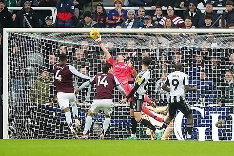 Aston Villa goalkeeper Emiliano Martinez saves an attempt on goal from Newcastle United's Lewis Miley during their English Premier League soccer match in Newcastle upon Tyne, England.