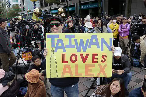 A fan of rock climber Alex Honnold, of the U.S., shows a poster before Honnold climbs the Taipei 101 skyscraper in Taipei, Taiwan.