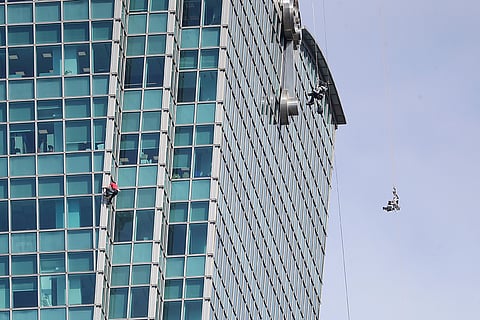 Rock climber Alex Honnold, of the U.S., center left, performs a free solo climb of the Taipei 101 skyscraper in Taipei, Taiwan.