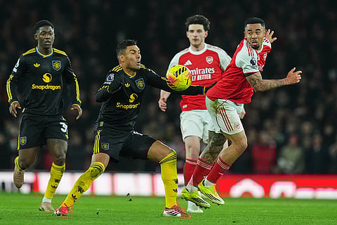 Arsenal's Gabriel Jesus, right, is challenged by Manchester United's Casemiro during the English Premier League soccer match between Arsenal and Manchester United in London.