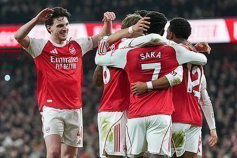 Arsenal players celebrate after Manchester United's Lisandro Martinez scored an own goal during the English Premier League soccer match between Arsenal and Manchester United in London.