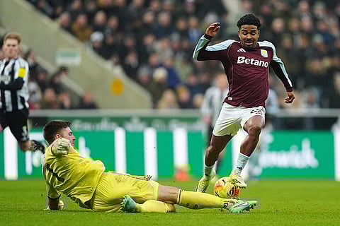 Aston Villa's Ian Maatsen, right, is tackled by Newcastle United goalkeeper Nick Pope during their English Premier League soccer match in Newcastle upon Tyne, England.