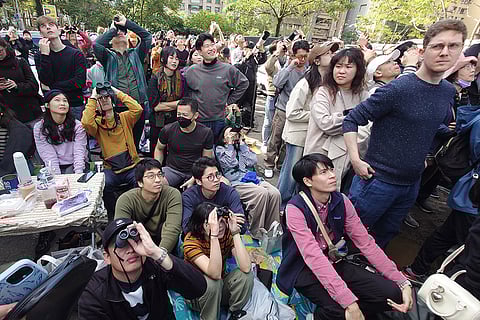 People watch rock climber Alex Honnold, of the U.S., climb the Taipei 101 skyscraper in Taipei, Taiwan.