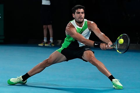 Carlos Alcaraz of Spain plays a backhand return to Alex de Minaur of Australia during their quarterfinal match at the Australian Open tennis championship in Melbourne, Australia.