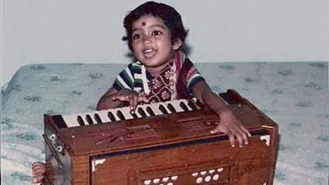 A childhood photograph of Arijit Singh learning to play the harmonium.