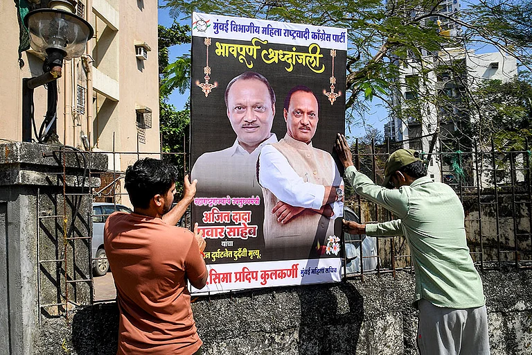 Workers set up a condolence banner following the passing away of Maharashtra Deputy Chief Minister Ajit Pawar, in Mumbai. Pawar, along with four others, was killed after an aircraft carrying them crashed near Baramati. - | Photo: PTI