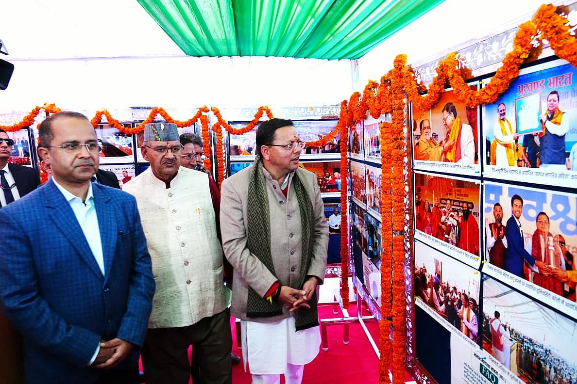 CM Dhami viewing photos of awardees