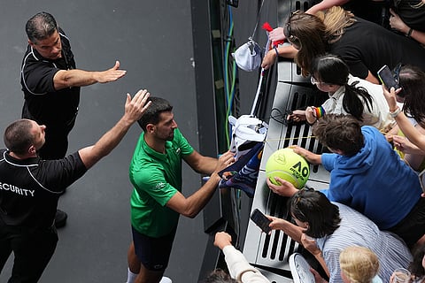 Novak Djokovic of Serbia signs autographs after his quarterfinal match against Lorenzo Musetti of Italy at the Australian Open tennis championship in Melbourne, Australia.
