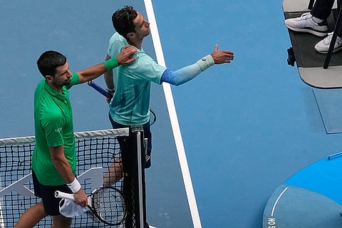 Novak Djokovic, left, of Serbia gestures to Lorenzo Musetti of Italy after Musetti withdrew from there quarterfinal match at the Australian Open tennis championship in Melbourne, Australia.