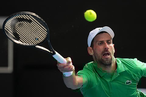 Novak Djokovic of Serbia plays a forehand return to Lorenzo Musetti of Italy during their quarterfinal match at the Australian Open tennis championship in Melbourne, Australia.