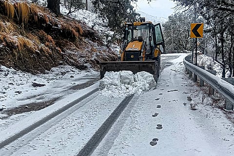 An earth-mover clears the snow-covered Gangotri highway after snowfall, in Uttarkashi, Uttarakhand.