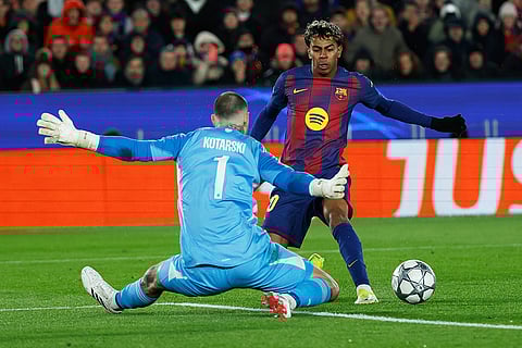 Barcelona's Lamine Yamal fights for the ball against Copenhagen's goalkeeper Dominik Kotarski during the Champions League opening phase soccer match between Barcelona and Copenhagen in Barcelona, Spain.