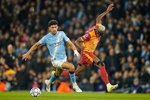 Manchester City's Matheus Nunes and Galatasaray's Victor Osimhen, right, battle for the ball during the Champions League opening phase soccer match Manchester City and Galatasaray in Manchester, England.