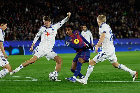 Copenhagen's William Clem fights for the ball against Barcelona's Alejandro Balde during the Champions League opening phase soccer match between Barcelona and Copenhagen in Barcelona, Spain.