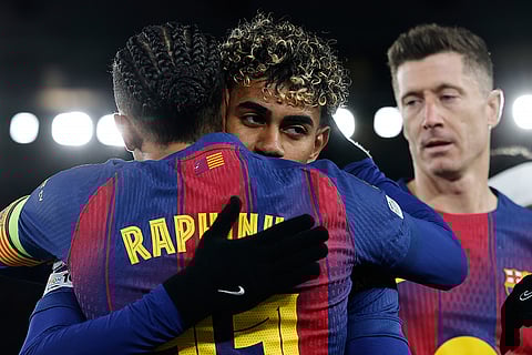 Barcelona's Raphinha celebrates with Lamine Yamal his side's third goal from a penalty kick during the Champions League opening phase soccer match between Barcelona and Copenhagen in Barcelona, Spain.