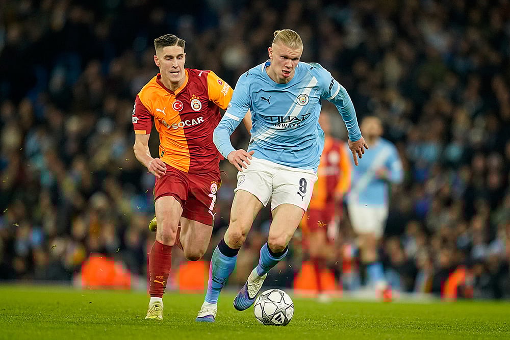Manchester City's Erling Haaland is chased by Galatasaray's Roland Sallai during the Champions League opening phase soccer match between Manchester City and Galatasaray in Manchester, England. - | Photo: AP/Dave Thompson