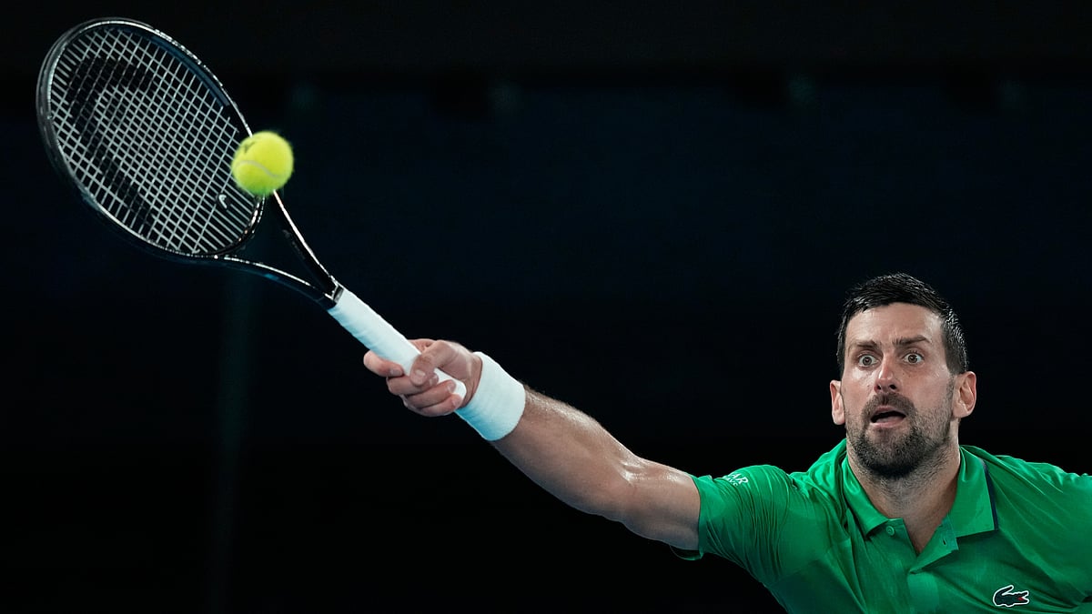 Novak Djokovic of Serbia plays a forehand return to Jannik Sinner of Italy during their semifinal match at the Australian Open tennis championship in Melbourne, Australia, Friday, Jan. 30, 2026.  - AP Photo/Aaron Favila