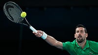 AP Photo/Aaron Favila : Novak Djokovic of Serbia plays a forehand return to Jannik Sinner of Italy during their semifinal match at the Australian Open tennis championship in Melbourne, Australia, Friday, Jan. 30, 2026. 