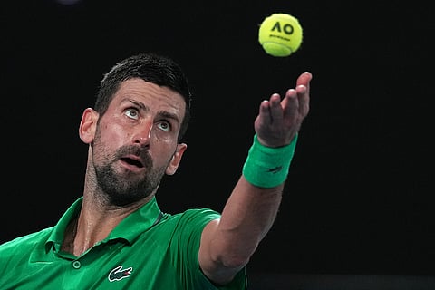 Novak Djokovic of Serbia serves to Jannik Sinner of Italy during their semifinal match at the Australian Open tennis championship in Melbourne, Australia.