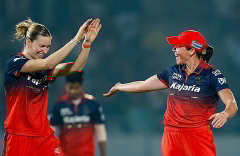 Royal Challengers Bengaluru’s Grace Harris, right, celebrates with Lauren Bell after taking the wicket of UP Warriorz’ Harleen Deol during a Women's Premier League (WPL) 2026 T20 International cricket match between Royal Challengers Bengaluru and UP Warriorz, at BCA Stadium, in Vadodara, Gujarat. 