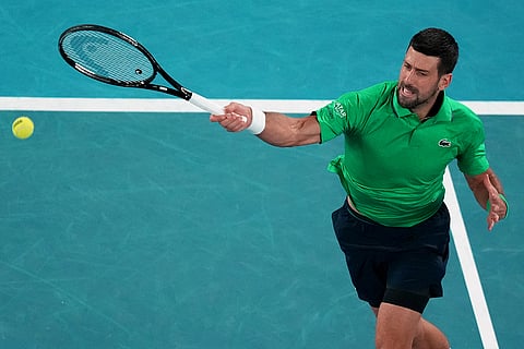 Novak Djokovic of Serbia plays a forehand return to Jannik Sinner of Italy during their semifinal match at the Australian Open tennis championship in Melbourne, Australia.