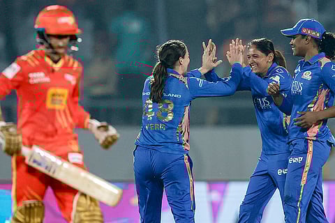 Mumbai Indians’ Amelia Kerr, back left, celebrates with captain Harmanpreet Kaur, back centre, and Hayley Matthews, right, after taking the wicket of Gujarat Giants’ Anushka Sharma during a Women's Premier League (WPL) 2026 T20 International cricket match between Gujarat Giants and Mumbai Indians, at BCA Stadium, in Vadodara, Gujarat. 