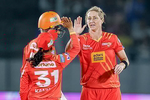 Gujarat Giants’ Sophie Devine, right, celebrates with teammates after taking the wicket of Mumbai Indians’ Hayley Matthews during a Women's Premier League (WPL) 2026 T20 International cricket match between Gujarat Giants and Mumbai Indians, at BCA Stadium, in Vadodara, Gujarat. 