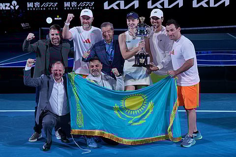 Elena Rybakina, center, of Kazakhstan holds the Daphne Akhurst Memorial Cup as she poses with her team after defeating Aryna Sabalenka of Belarus to win the women's singles final at the Australian Open tennis championship in Melbourne, Australia.