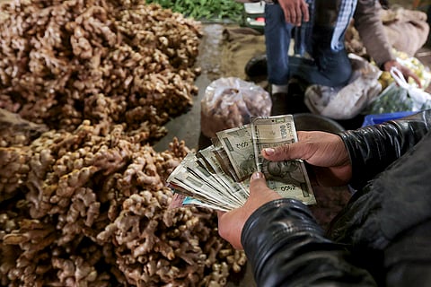 A man counts cash at a wholesale market, ahead of the presentation of the Union Budget 2026-27 by Union Finance Minister Nirmala Sitharaman, in Prayagraj.