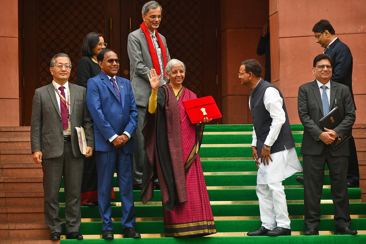 Indian Finance Minister Nirmala Sitharaman, center, displays a red folder containing the Union Budget 2026-27 at the steps of the parliament house before tabling it, in New Delhi, India, Sunday, Feb. 1, 2026. - | Photo: AP
