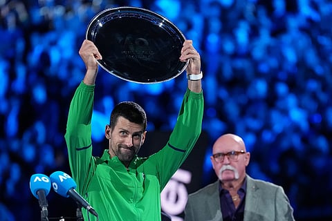 Novak Djokovic of Serbia holds up his runner-up trophy after his loss to Carlos Alcaraz of Spain in the men's singles final at the Australian Open tennis championship in Melbourne, Australia.