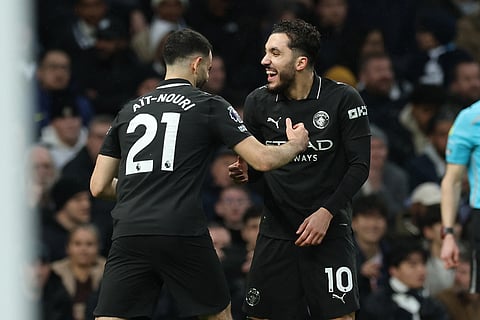 Manchester City's Rayan Cherki, right, celebrates scoring his side's opening goal during the English Premier League soccer match between Tottenham Hotspur and Manchester City in London.