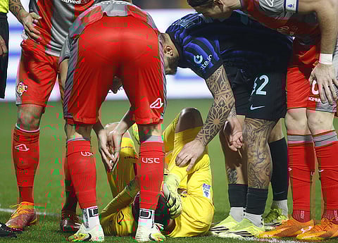 Cremonese's goalkeeper Emil Audero lies on the pitch after fans throw a flair towards him during the Serie A soccer match between Cremonese and Inter in Cremona, Italy.