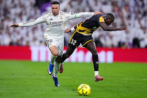 Real Madrid's Kylian Mbappe, vies for the ball with Rayo's Nobel Mendy during the Spanish La Liga soccer match between Real Madrid and Rayo Vallecano in Madrid, Spain.