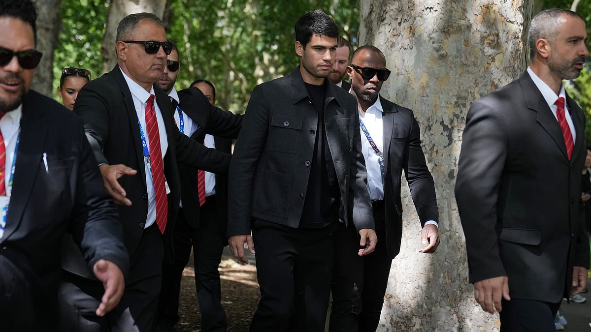 Carlos Alcaraz of Spain, center, is escorted by security guards the morning after defeating Novak Djokovic of Serbia in the men's singles final at the Australian Open tennis championship, in Melbourne, Australia, Monday, Feb. 2, 2026. - | Photo: AP/Dita Alangkara