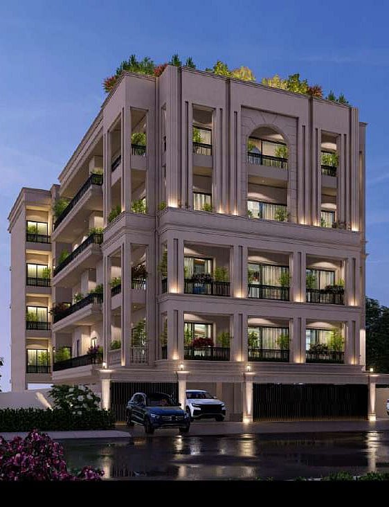 Modern multi-story residential building with lit balconies and cars parked in front.