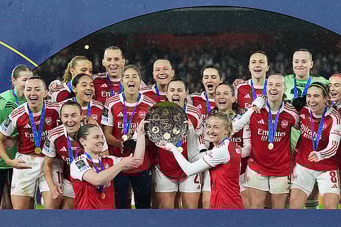 Arsenal's team captains Kin Little, left, and Leah Williamson, right, lift the trophy after winning the Women's Champions Cup final soccer match between Arsenal FC and SC Corinthians in London.
