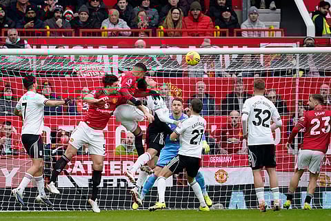 Manchester United's Casemiro, top center, scores the opening goal during the English Premier League soccer match between Manchester United and Fulham in Manchester, England.